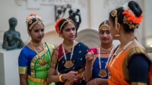 4 Asian young women in colourful clothing chatting at Bristol Museum 